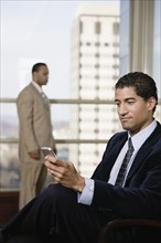 Mixed race businessman using cell phone