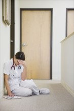 Nurse sitting on floor feeling ill