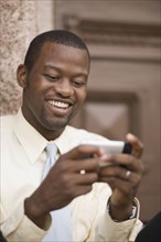 African businessman sending text message