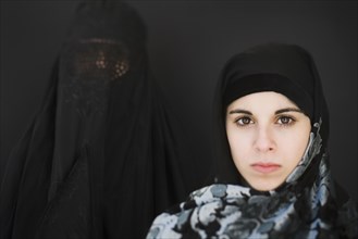 Middle Eastern woman in burka and teenager in headscarf