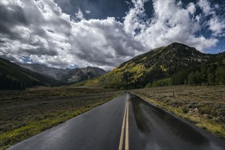 Wet two-lane road near mountains