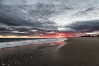 Ocean waves on beach at sunset