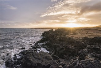 Sunset on rocky ocean beach