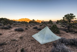Tent in desert at sunset