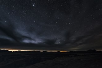 Clouds and stars in sky over desert