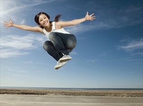 Asian woman jumping in air
