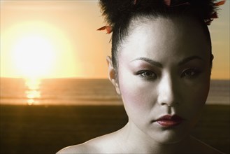 Asian woman in front of sunset