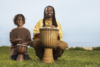 African father and son playing drums