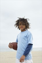 Mixed Race boy holding football