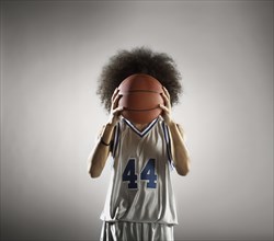 Mixed race basketball player holding basketball