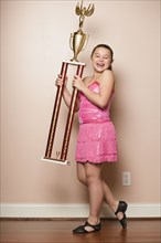 Mixed Race girl holding dancing trophy