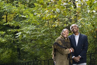 Senior African couple smiling in woods