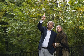 Senior African couple pointing in woods