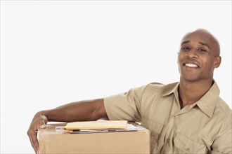 Studio shot of African delivery man with package