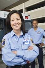 Asian female paramedic with co-worker in background