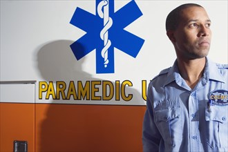 African male paramedic next to ambulance