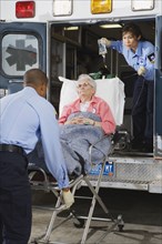 Paramedics putting senior woman into ambulance