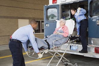 Paramedics putting senior woman into ambulance