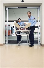 Paramedics wheeling person into hospital