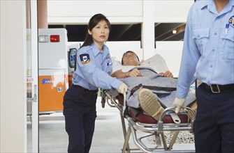 Paramedics wheeling man into hospital