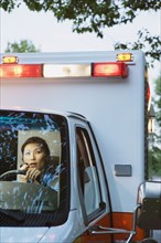 Asian female paramedic driving ambulance