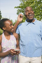 African grandfather listening to granddaughter's mp3 player