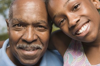 Close up of African grandfather and granddaughter smiling