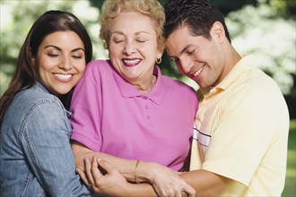Hispanic mother with adult children hugging