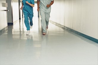 Two nurses running down corridor in hospital