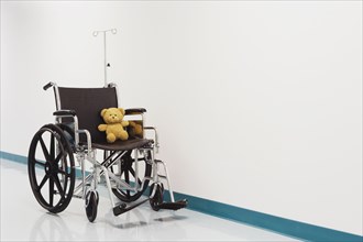 Wheelchair with teddy bear in hospital corridor