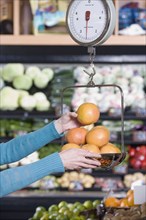 Woman weighing fruit at grocery store