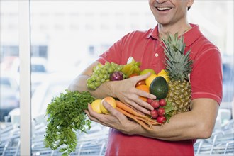 Man holding fresh fruit and vegetables at grocery store