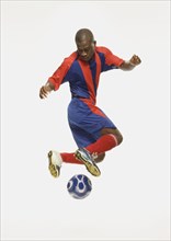 African American male soccer player kicking ball