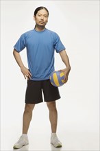 Asian man holding volleyball