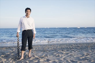 Asian businessman standing on beach