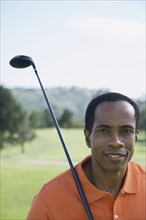 African man holding golf club