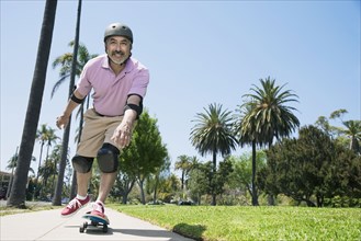 Hispanic man riding skateboard
