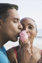 Multi-ethnic couple eating ice cream cone