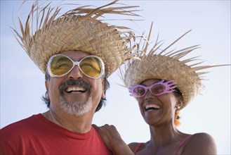 Multi-ethnic couple wearing straw hats