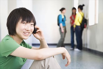 Chinese woman talking on cell phone in corridor
