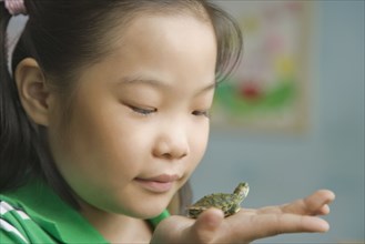 Chinese girl holding miniature turtle