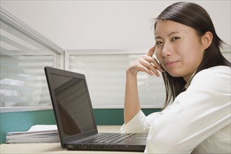 Chinese businesswoman using laptop at desk