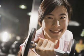 Chinese woman holding dumbbell