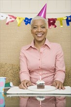 African woman with cupcake at birthday party