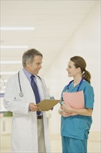 Doctor talking to nurse in hospital hallway