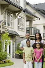 African American family standing outside house