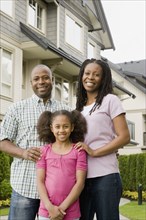 African American family standing outside house