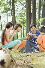 Family eating watermelon in forest