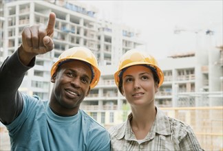 Man and woman in hard-hats on construction site
