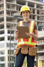 Mixed race woman in hard-hat on construction site
